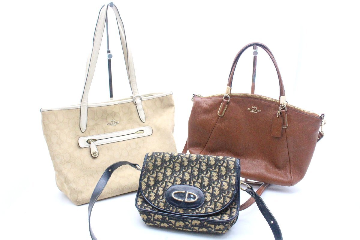 Three bags on a white background: a beige canvas tote, a brown leather handbag, and a small Christian Dior monogram crossbody bag.