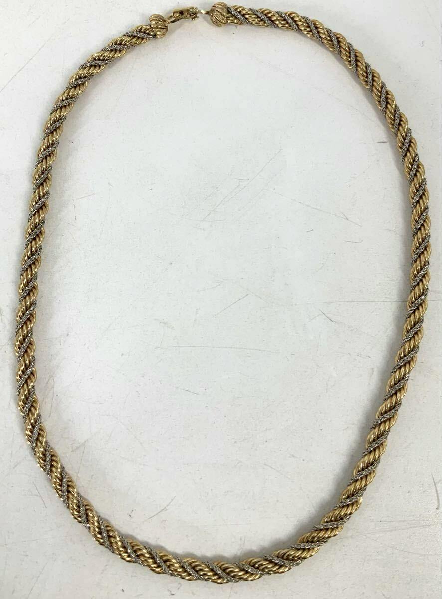 Twisted rope-style necklace with gold and silver tones laid flat on a white background showing the full length and clasp.