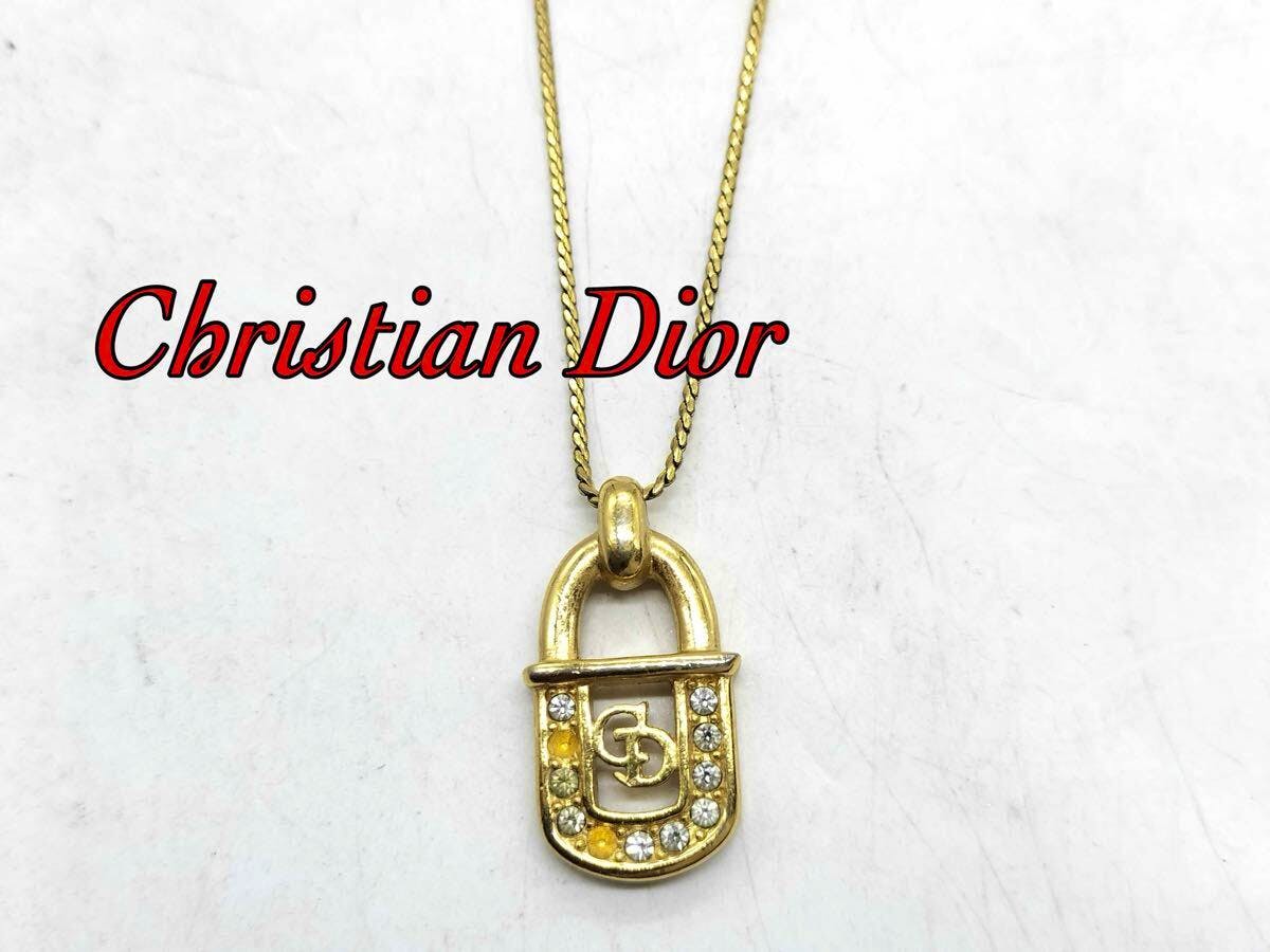 Gold Christian Dior padlock pendant necklace with CD logo and rhinestones shown on a chain.