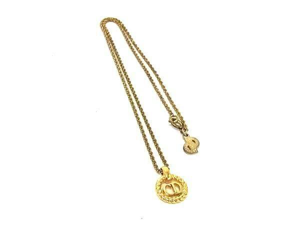 Gold-tone Christian Dior necklace with a round CD logo pendant and chain displayed on a white background.
