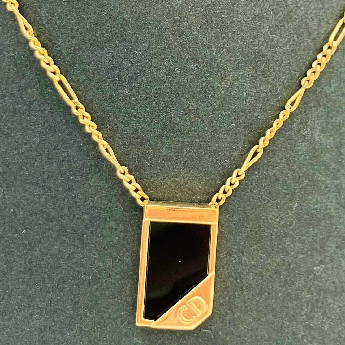 Christian Dior gold-plated necklace with a black rectangular pendant and a small CD logo plate shown on a dark background.