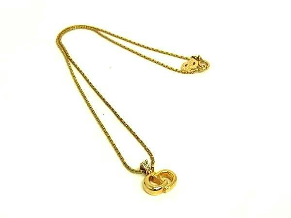 Gold-tone Christian Dior necklace with CD logo pendant and chain on a white background.