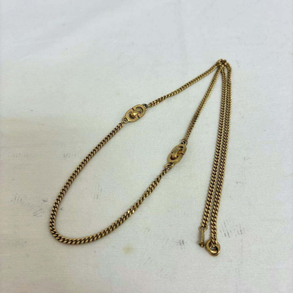 Gold-color Christian Dior necklace with CD logo links laid flat on a white background.