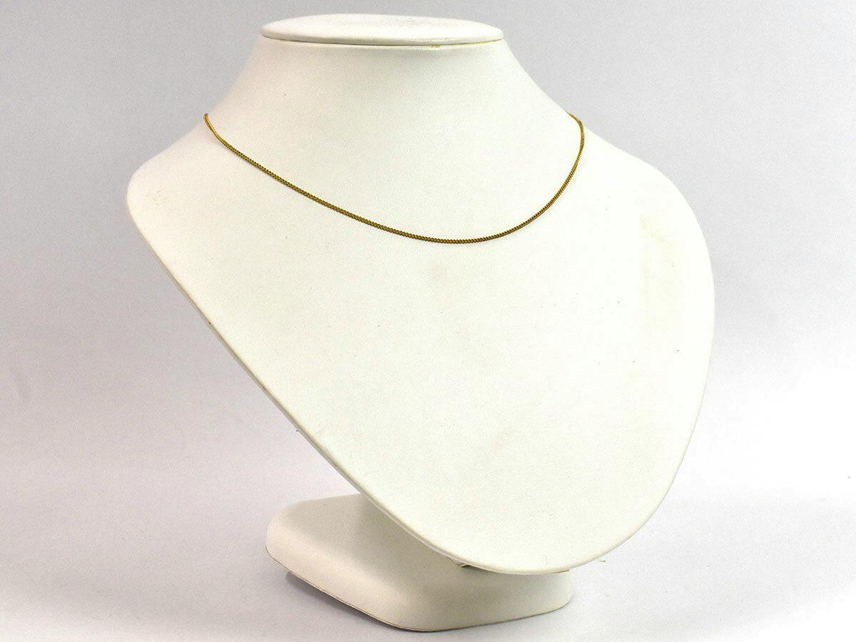 Gold-tone chain necklace displayed on a white jewelry bust.