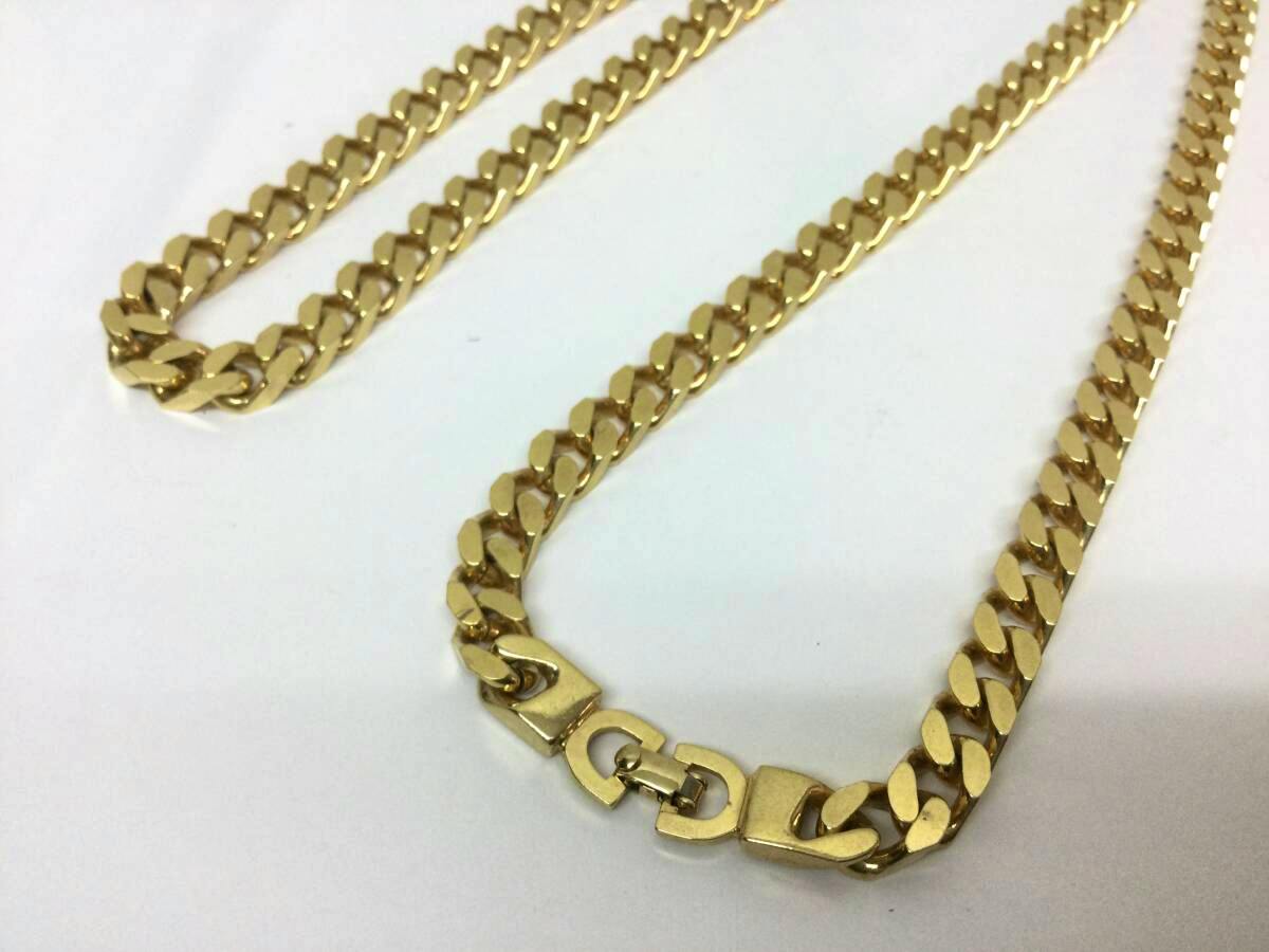 Christian Dior gold-color curb chain necklace with clasp laid flat on a white background.