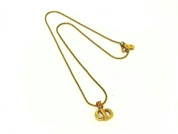 Gold-tone Christian Dior vintage necklace with a pendant on a thin chain shown on a white background.