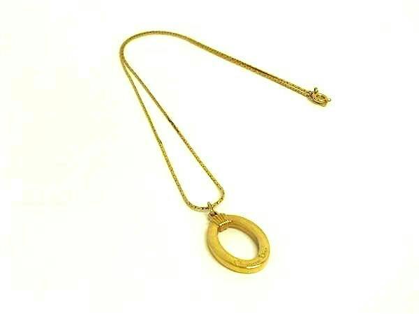 Gold-tone Christian Dior vintage necklace with an oval pendant on a white background.