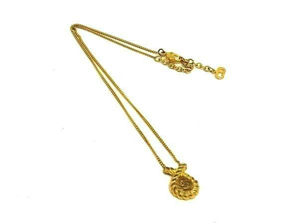 Gold-tone Christian Dior vintage necklace with a small pendant laid flat on a white background.