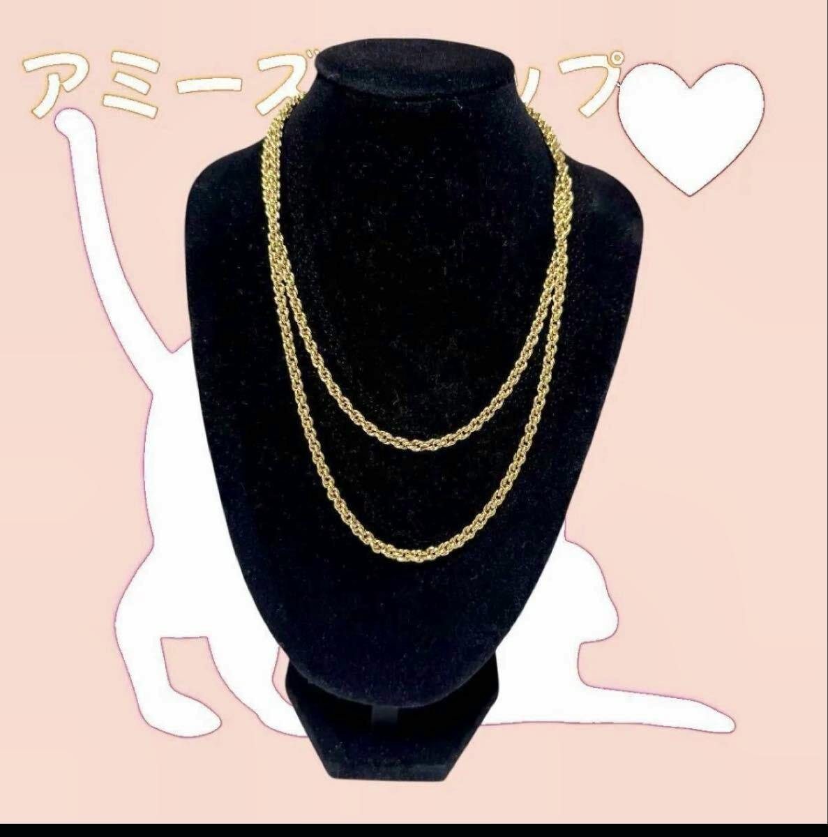 Gold-tone long double-layer Christian Dior necklace displayed on a black jewelry bust.