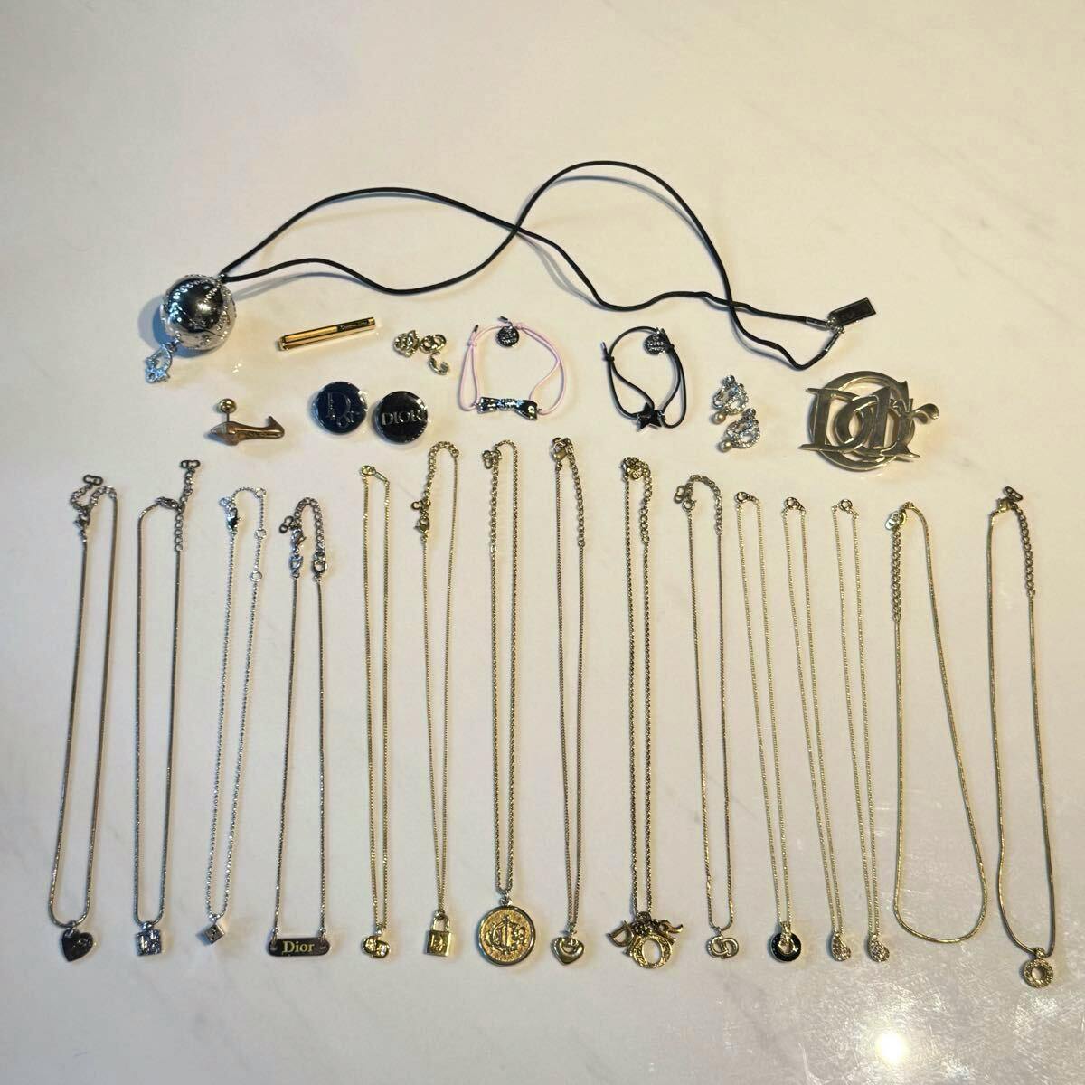 Assorted Christian Dior necklaces, earrings, brooches, and other accessory pieces arranged on a white surface.