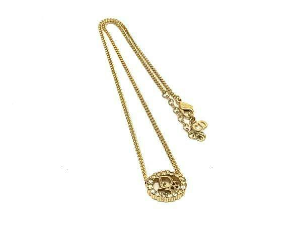 Gold-tone Christian Dior vintage necklace with a round rhinestone pendant on a white background.