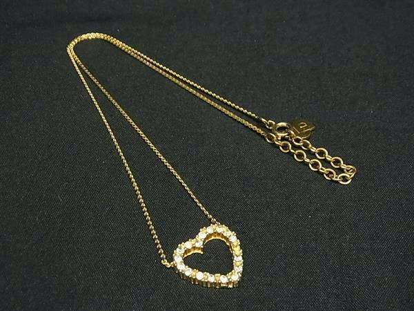 Gold-tone Christian Dior vintage rhinestone heart pendant necklace displayed on black fabric.