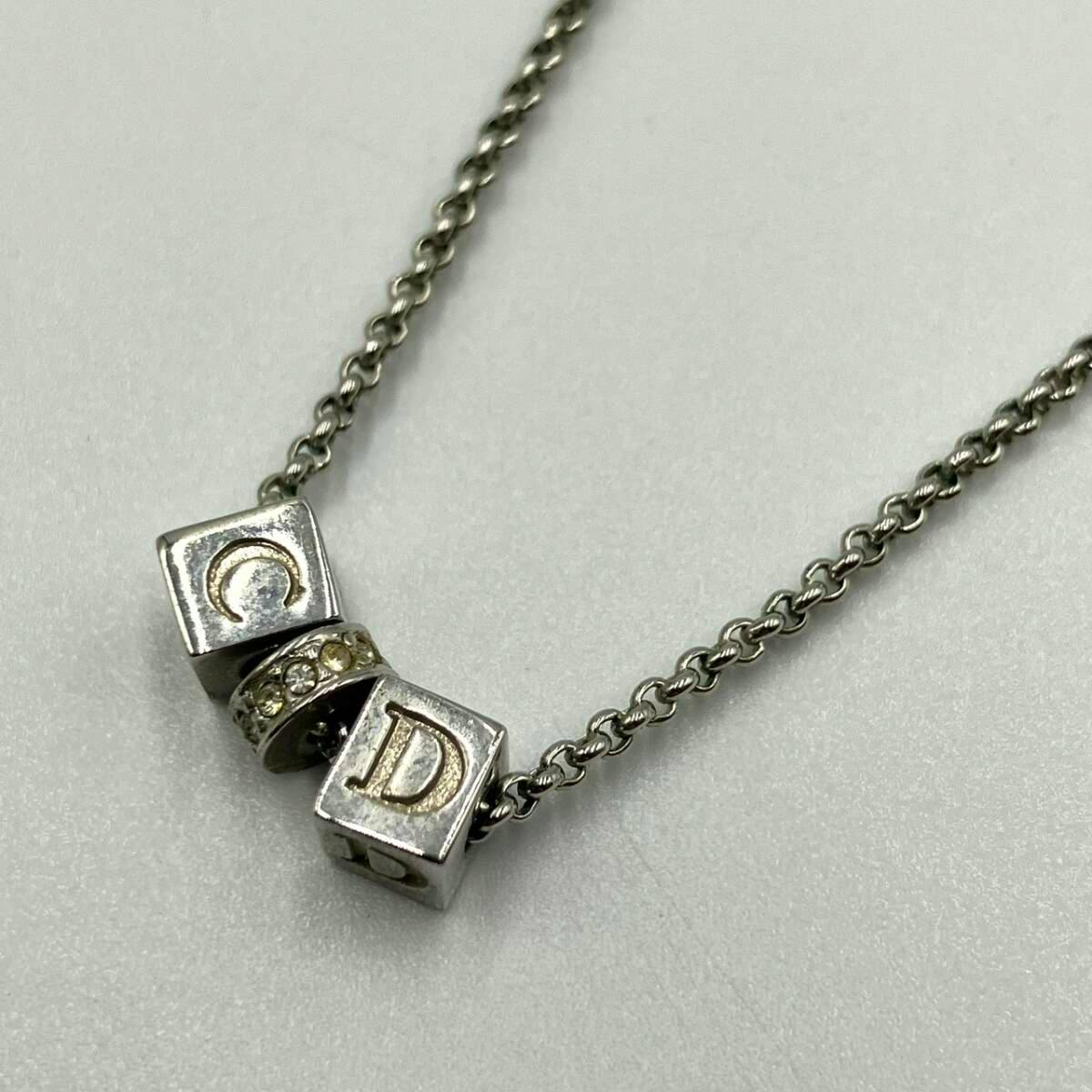 Silver-tone necklace chain with cube letter beads showing "C" and "D" and a small rhinestone spacer.