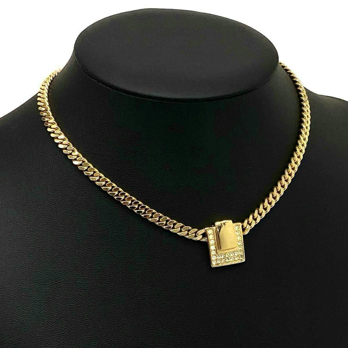 Gold-tone curb chain necklace with a square rhinestone-accented pendant displayed on a black mannequin bust.