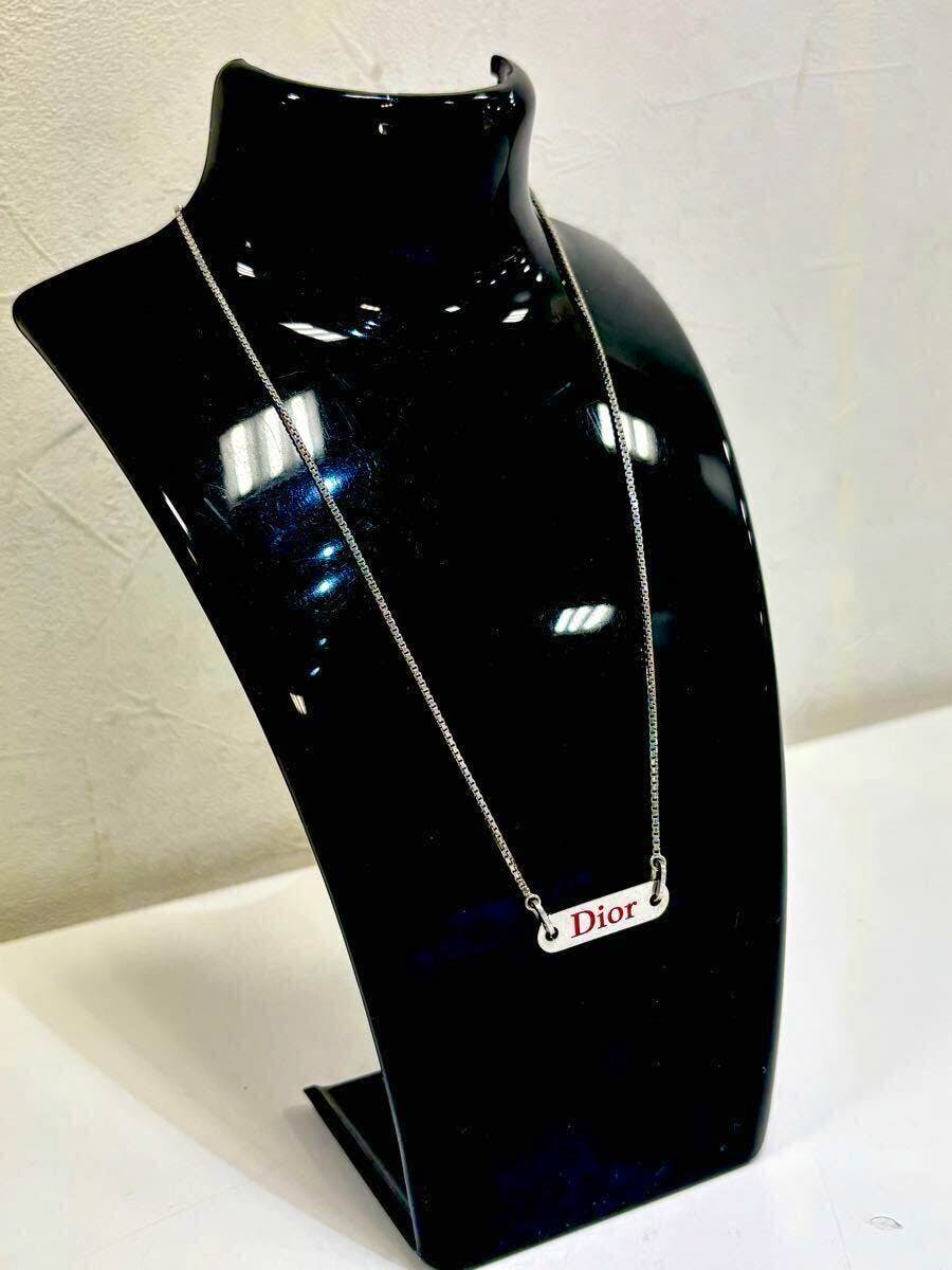 Silver-color Christian Dior logo-plate necklace displayed on a black necklace bust.