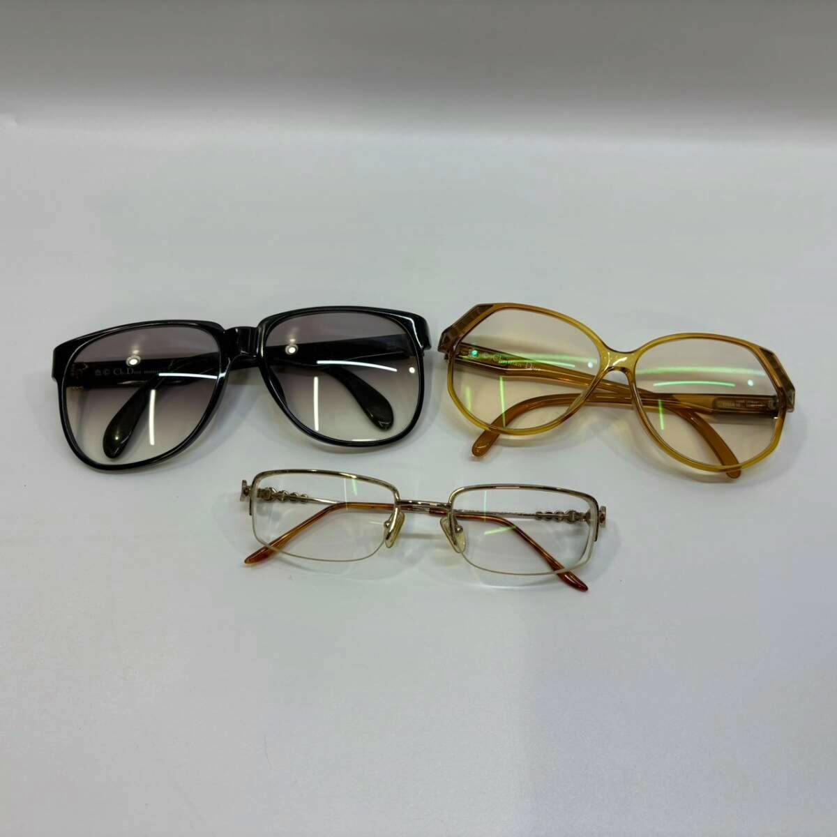 Three pairs of Christian Dior glasses, including two sunglasses and one eyeglass frame, arranged on a white background.
