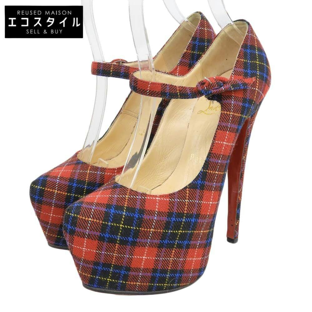Red tartan-check canvas platform Mary pumps with high stiletto heels shown on clear shoe forms.