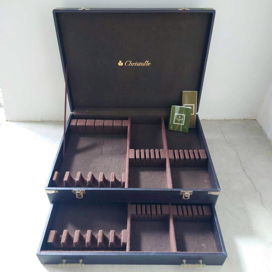 Open two-tier Christofle cutlery storage box showing brown felted compartments and the Christofle logo on the inside of the lid.