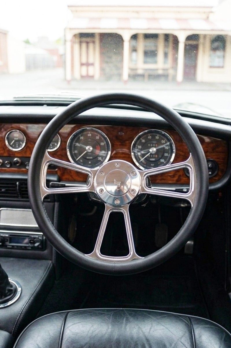 Chrome three-spoke steering wheel installed in a car interior, centered on the dashboard.