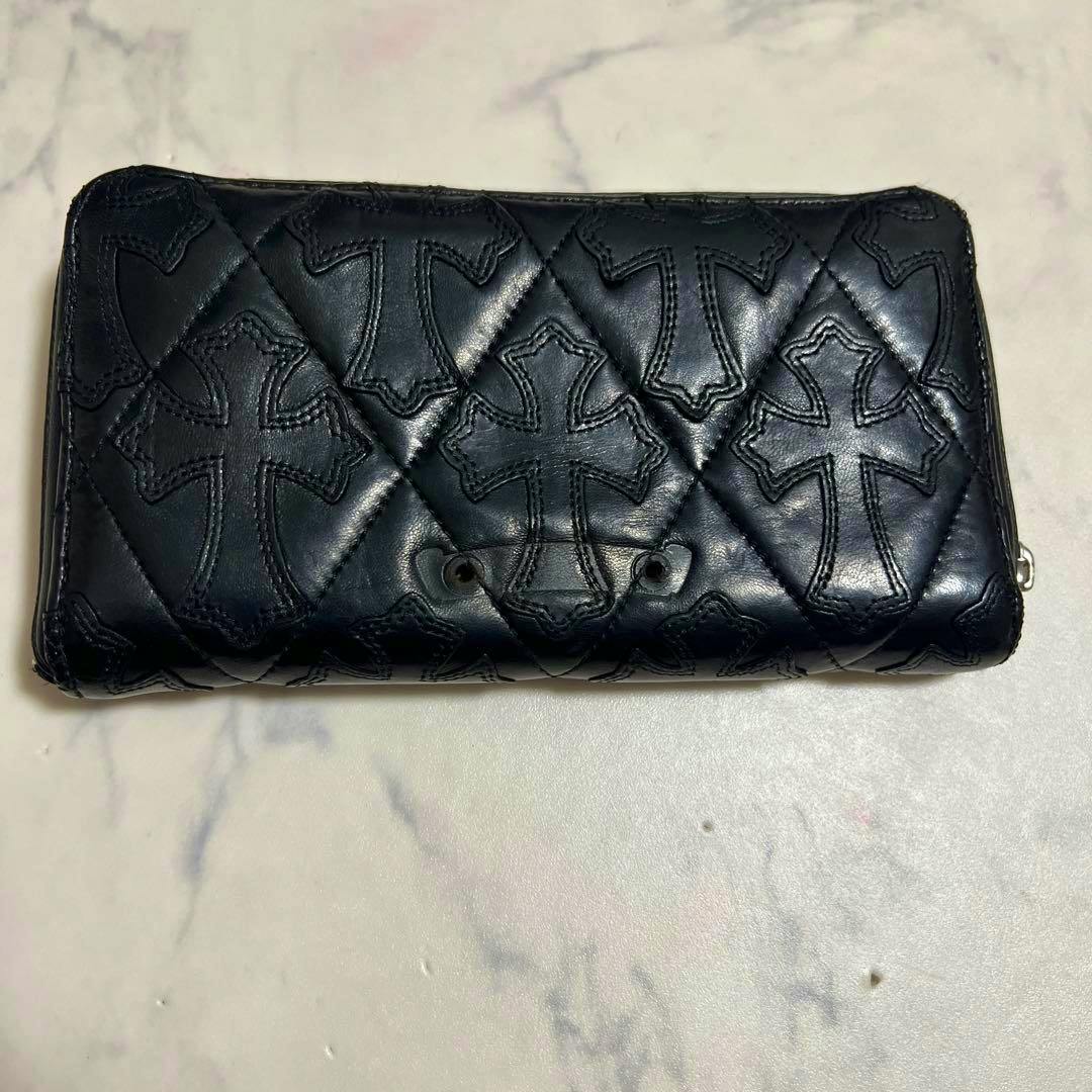 Black Chrome Hearts quilted long wallet with stitched cross motifs laid flat on a light marble surface.