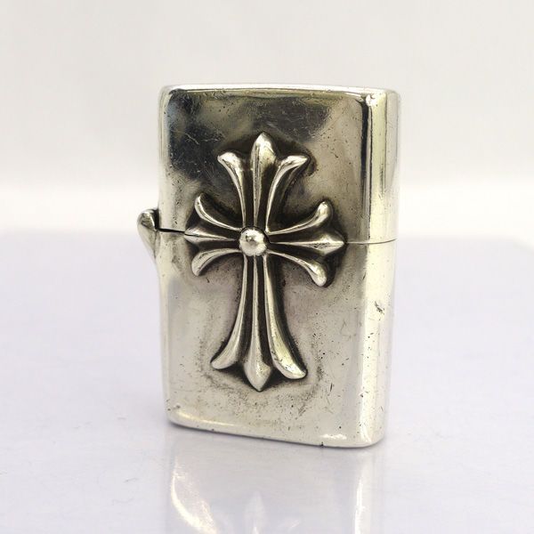 Front view of CHROME HEARTS V1 small Zippo-style metal lighter with a raised cross emblem.