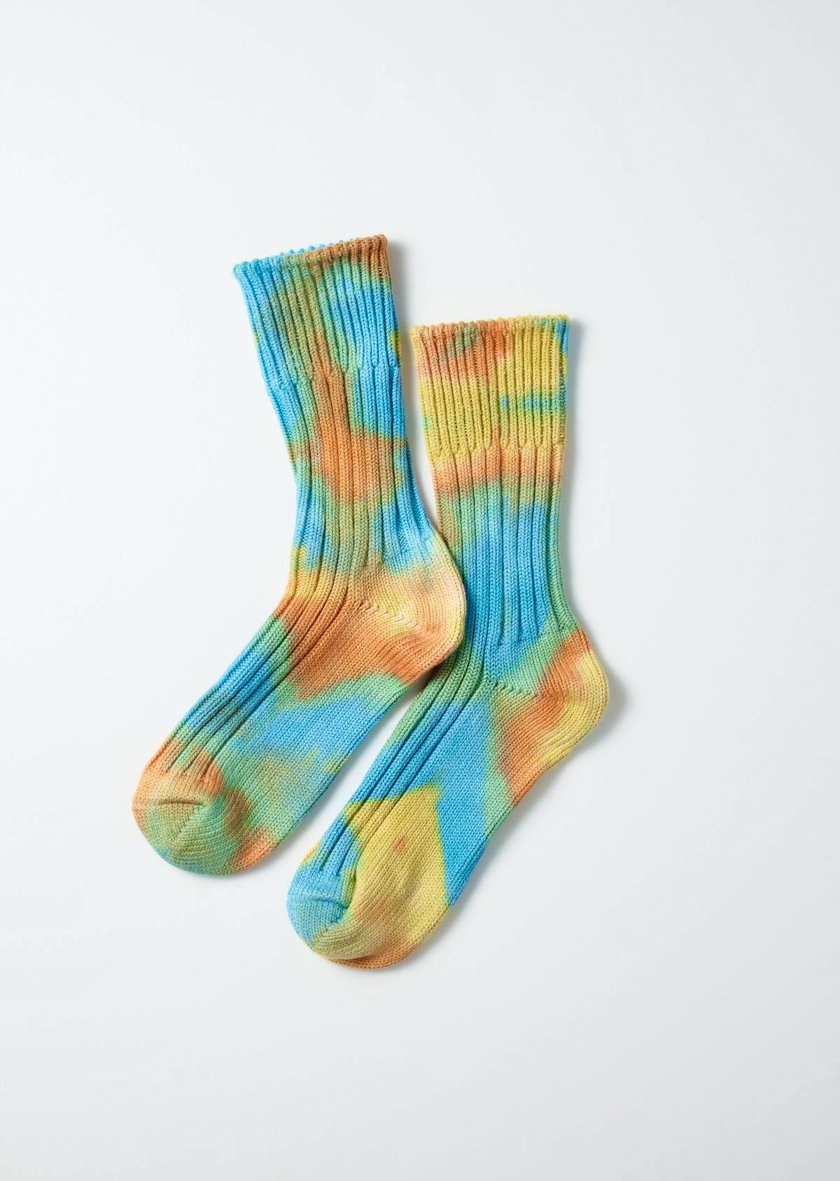 Pair of tie-dye chunky rib crew socks in blue, yellow, and orange displayed flat on a white background.