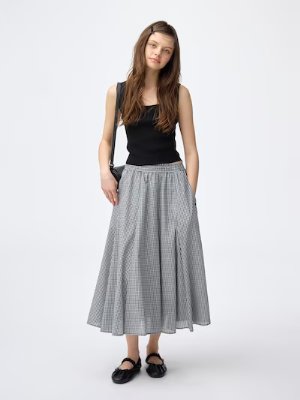 Model wearing the circular midi skirt in a black-and-white checked pattern, shown full length.
