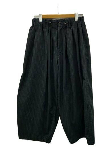 Front view of the men's polyester circular pants in black with vertical stripes hanging on a wooden hanger.
