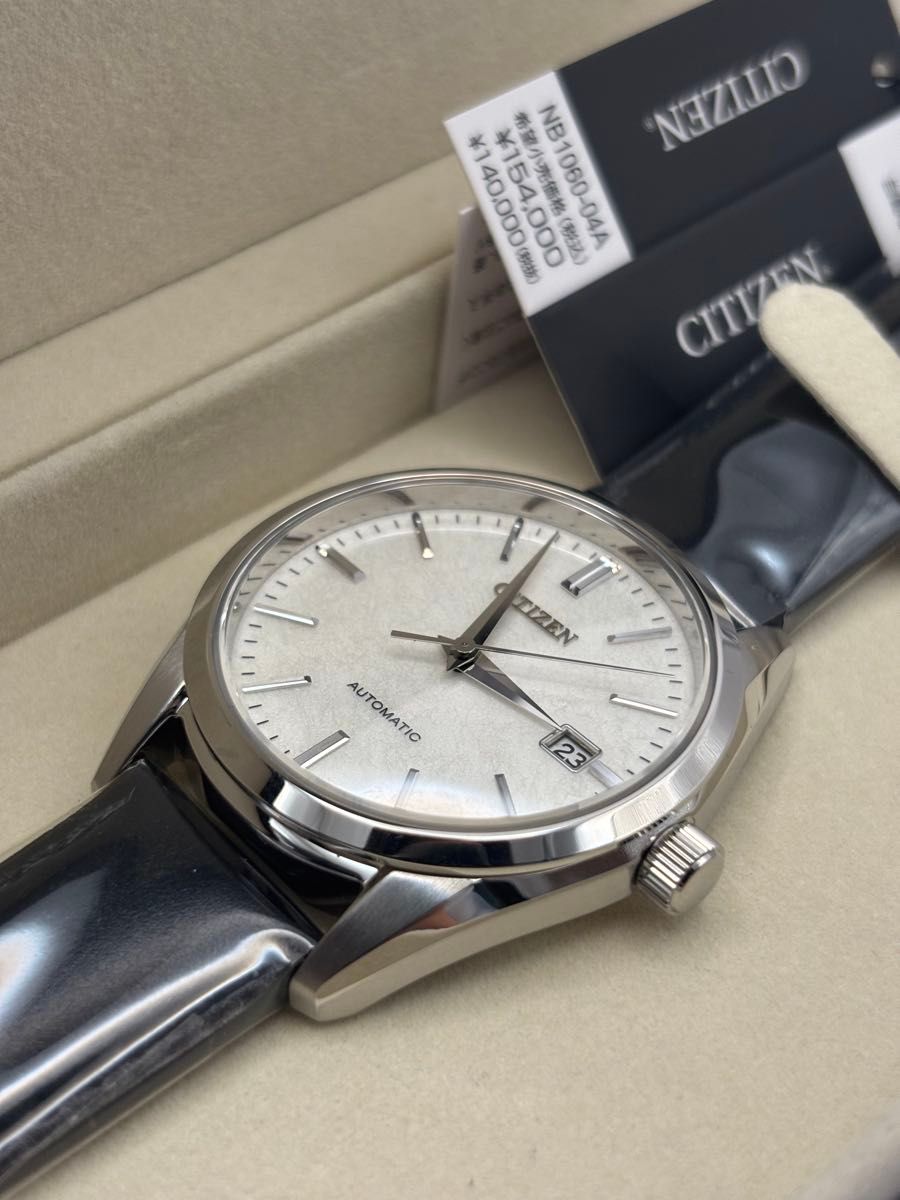 Citizen NB1060-04A automatic wristwatch with a silver-leaf lacquer dial and date display shown in its box.