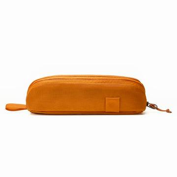 Burnt orange nylon pouch with a top zipper, small side loop, and square tab, photographed on a white background.