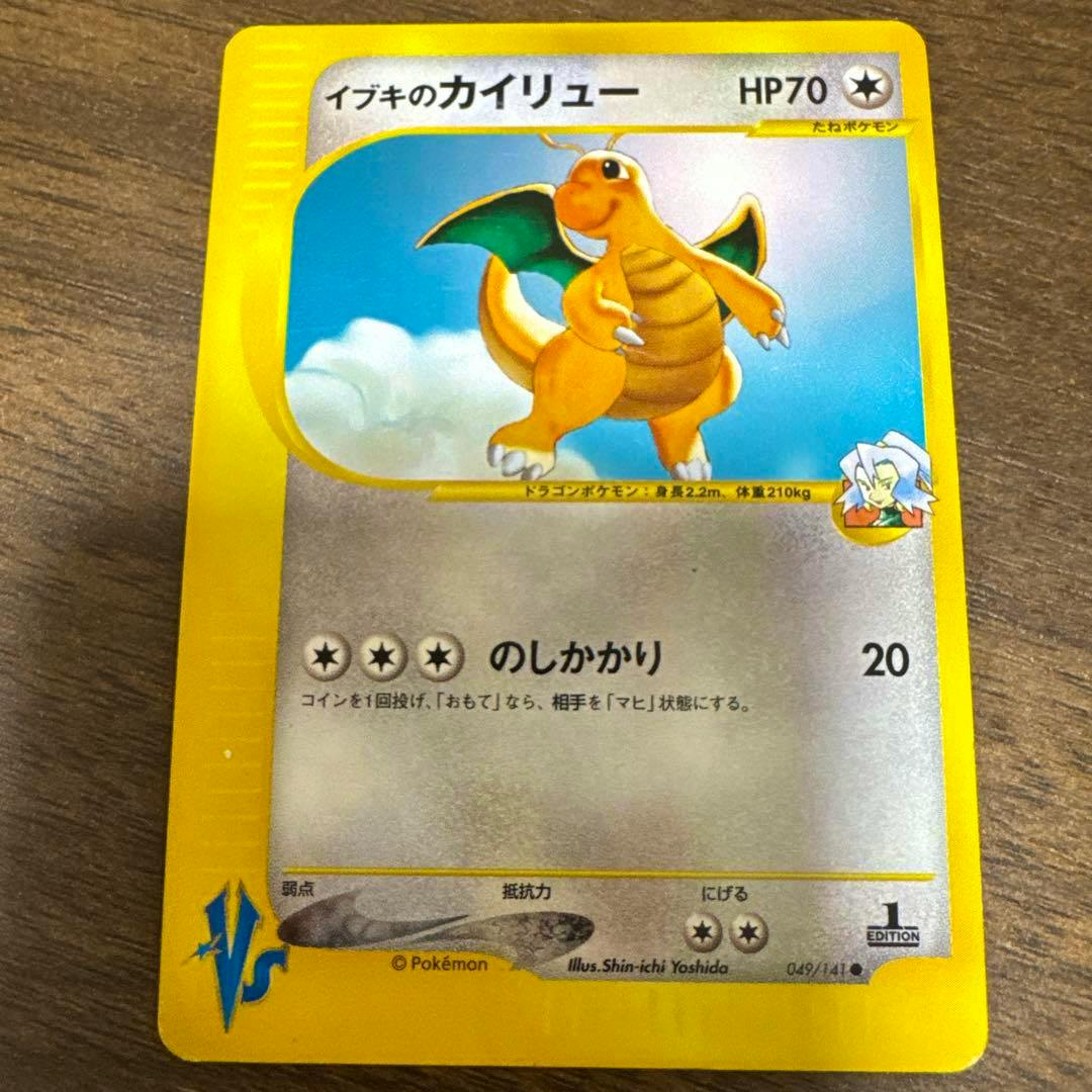 Photograph of the Japanese trading card イブキのカイリュー (Dragonite) showing the front of the card on a wooden surface.