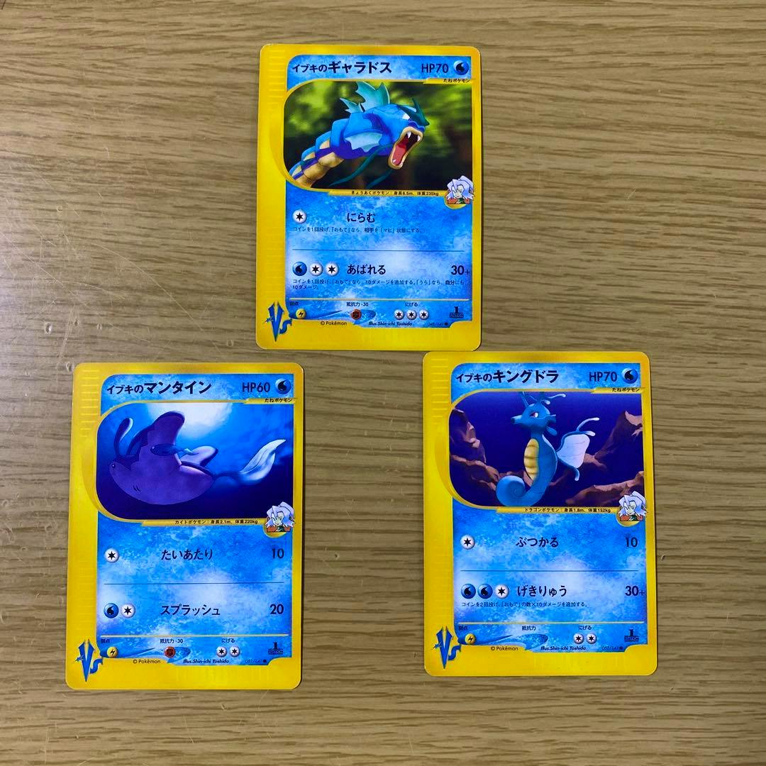Three Japanese Pokémon VS trading cards (イブキのギャラドス, イブキのマンタイン, イブキのキングドラ) laid on a wooden surface.