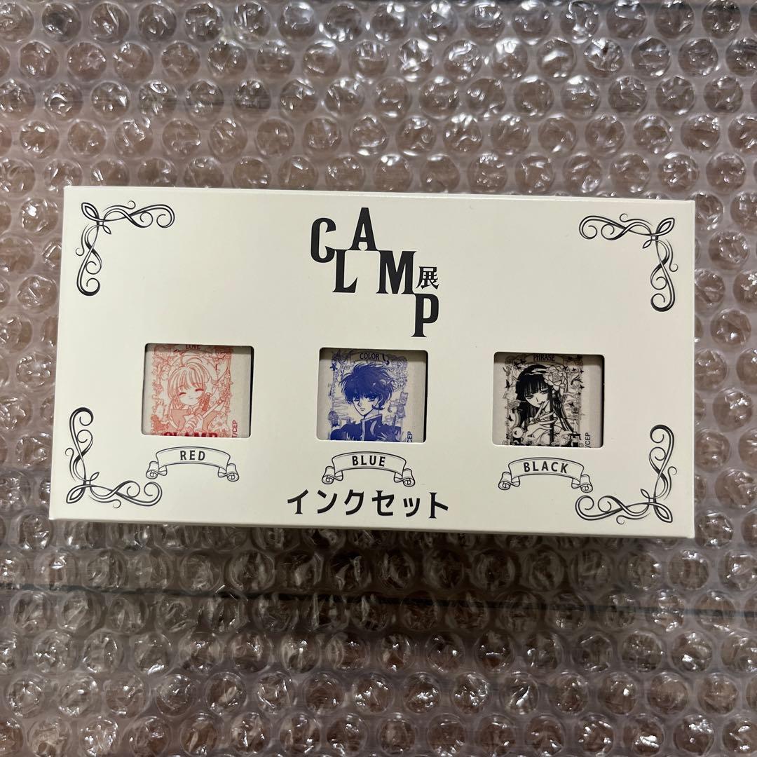 Front view of the boxed CLAMP exhibition fountain pen ink set showing three small windows with red, blue, and black inks visible.