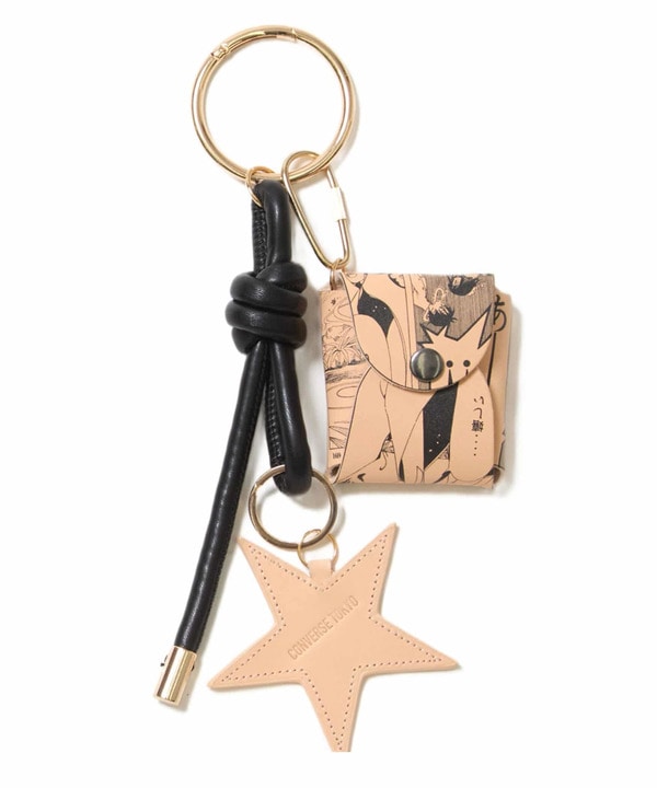 A xxxHOLiC pouch charm keyring showing a small printed pouch, a star-shaped leather charm, and a knotted black strap on a gold ring.