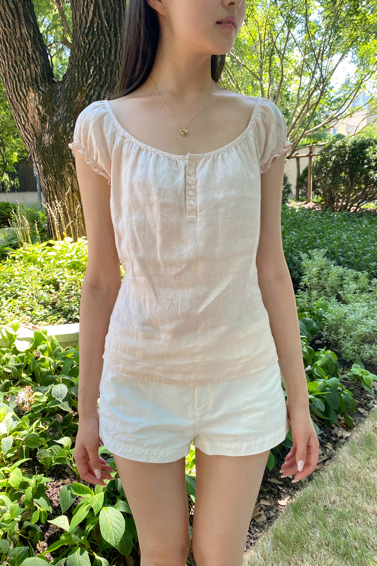 Front view of the Clarisse Top, a women's cotton blouse worn by a model outdoors.