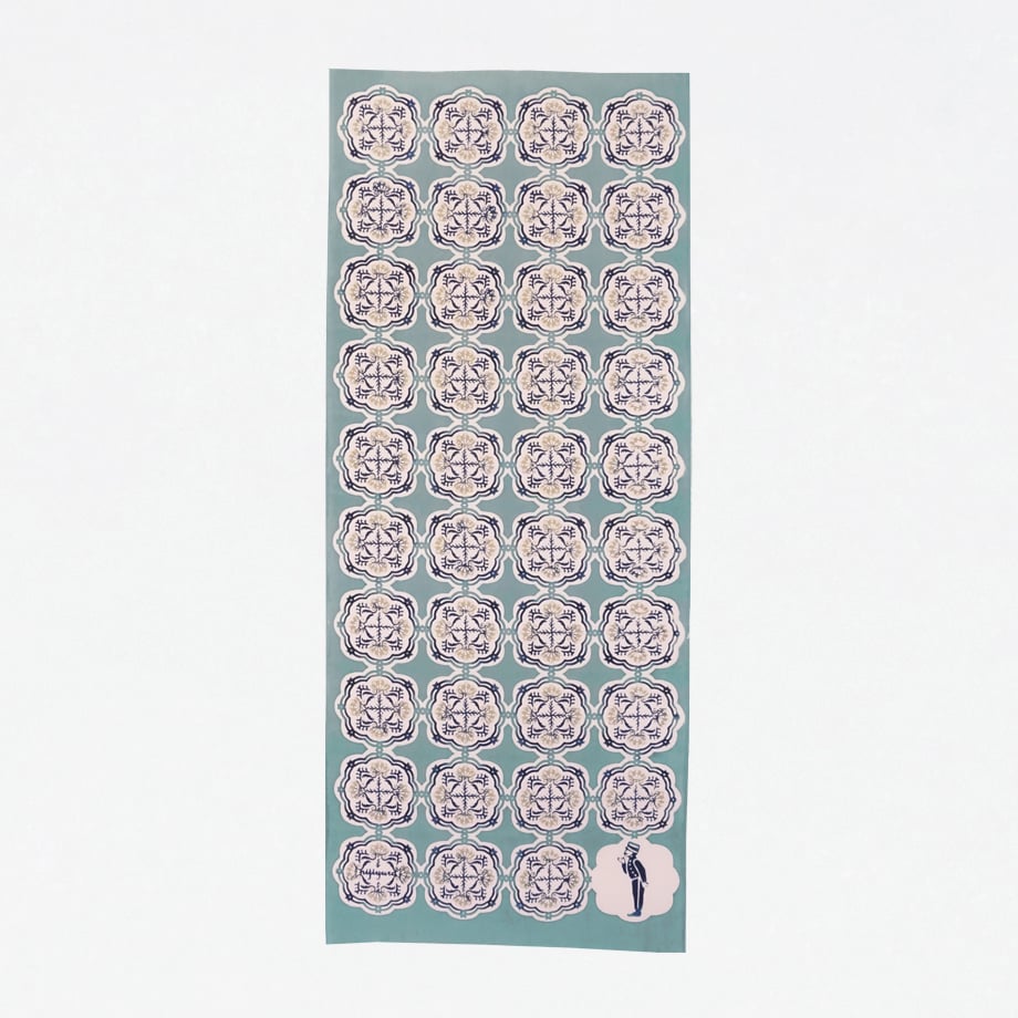 Full-length green cotton tenugui (scarf) laid flat showing repeating circular decorative motifs on a white background.