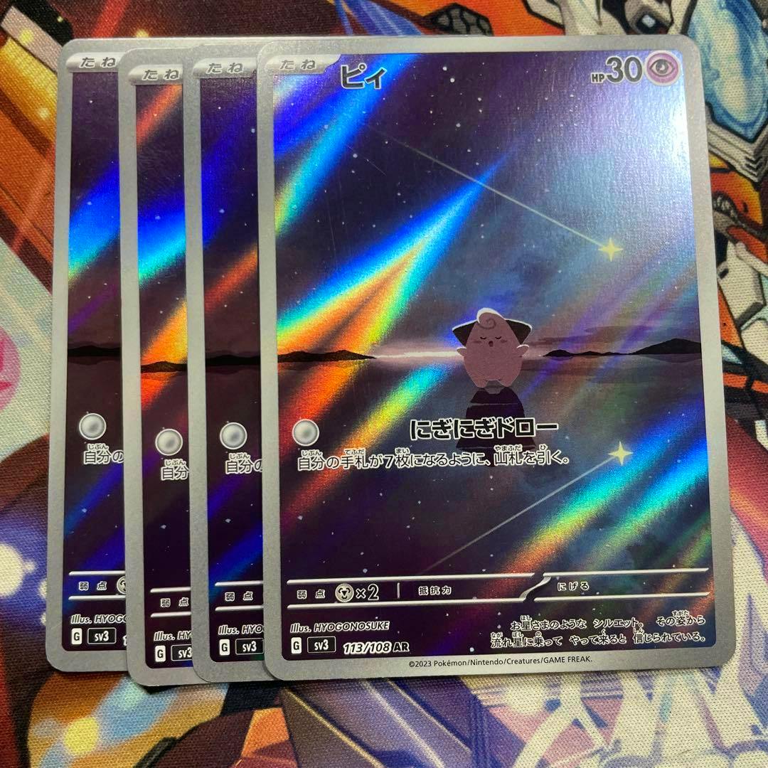 Photo of four holographic ピィ trading cards (Scarlet & Violet, 113/108) fanned overlapping on a surface.