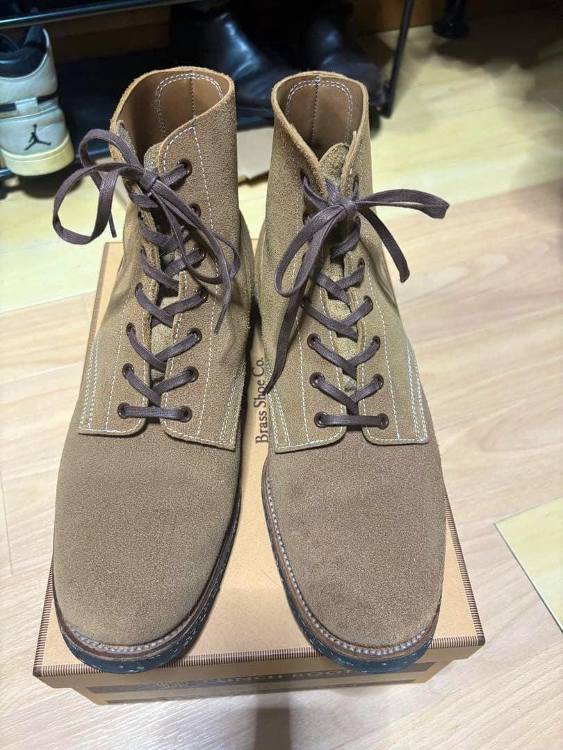 Top-down view of a pair of brown suede CLINCH Yeager boots laced and resting on their shoebox.