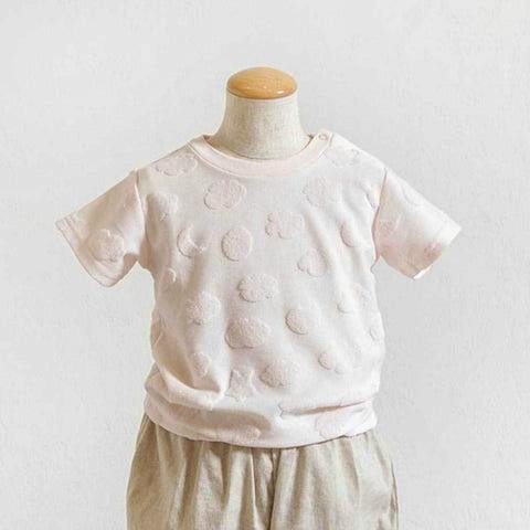 Pale pink cloud-pile short-sleeve T-shirt displayed on a child mannequin, showing textured cloud-like raised dots.