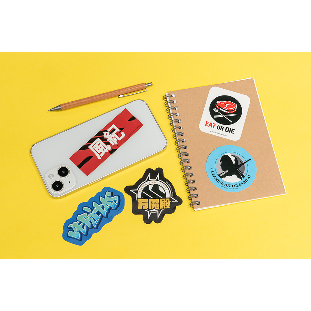 Five 部活ロゴ stickers displayed on a yellow background on a smartphone, a notebook, and loose on the surface.