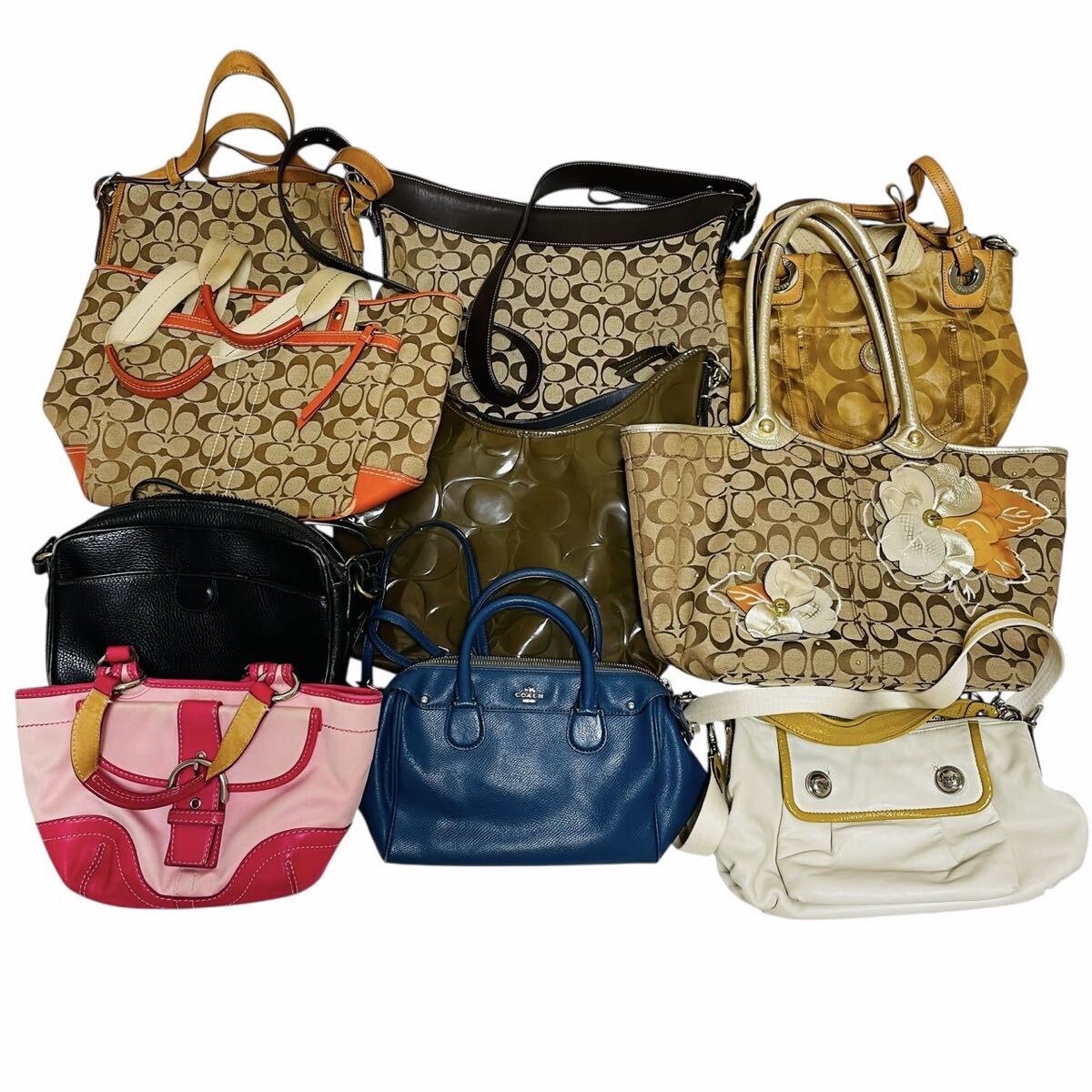 A grouped set of Coach handbags and totes arranged together on a white background.