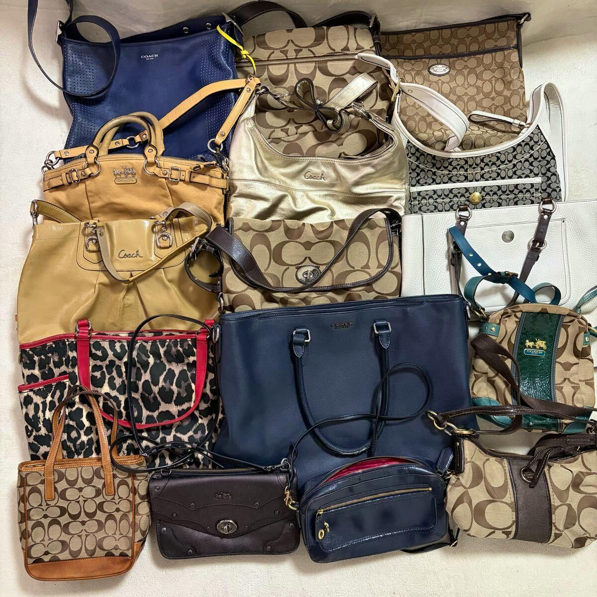 A collection of multiple Coach handbags and shoulder bags arranged on a light surface, showing various styles, patterns, and colors.