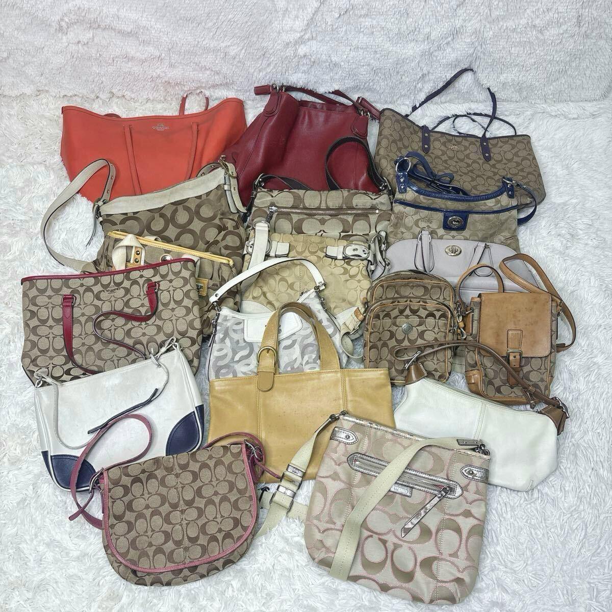 Eighteen COACH canvas and leather handbags and shoulder bags arranged together on a white surface.