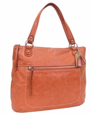 Orange leather Coach tote bag with a front zip pocket and double shoulder handles.