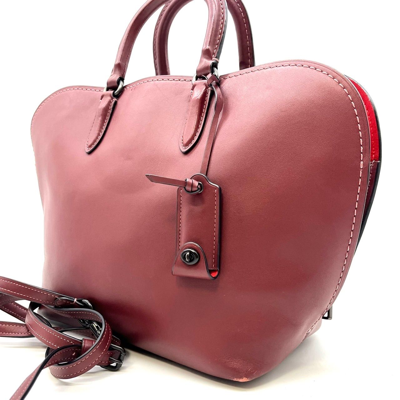 Red COACH 2way leather shoulder/handbag with turn-lock charm and strap shown front-side.