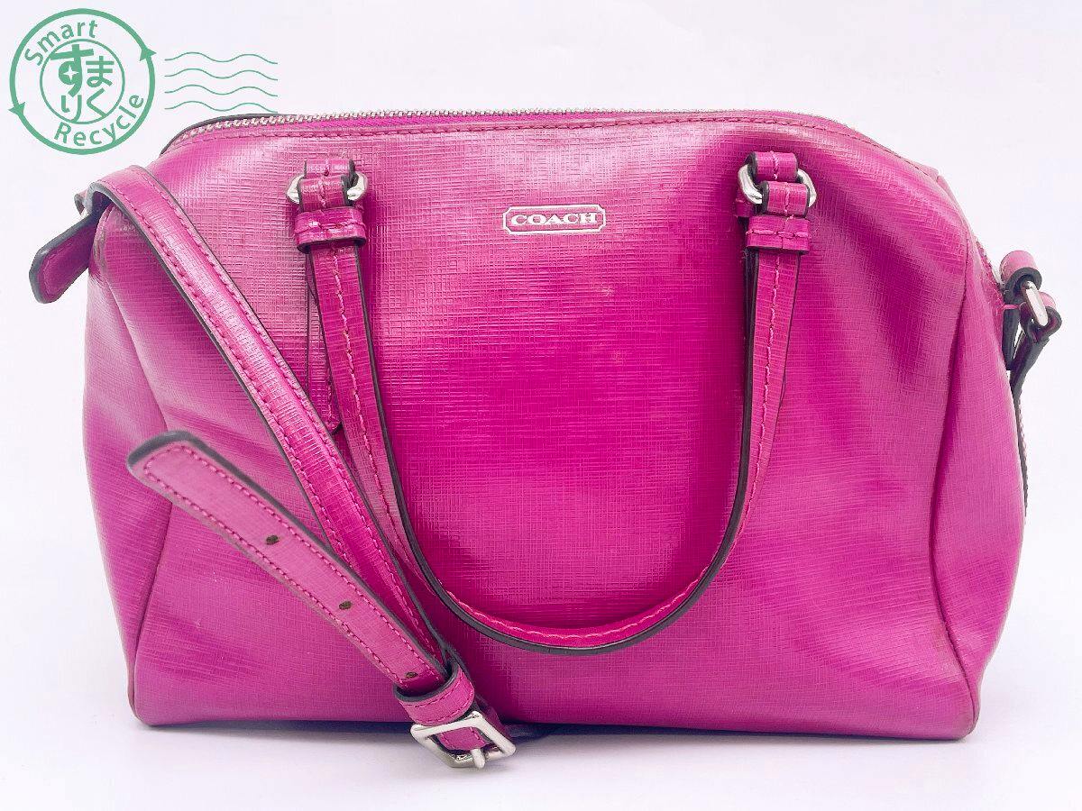 Front view of a pink COACH 2-way mini Boston handbag in patent leather with top handles and an adjustable shoulder strap.