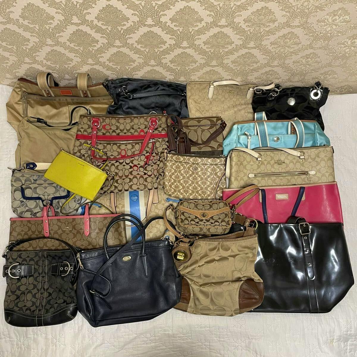 Several Coach bags and totes laid flat showing signature monogram canvas, leather, and vinyl styles in various colors.