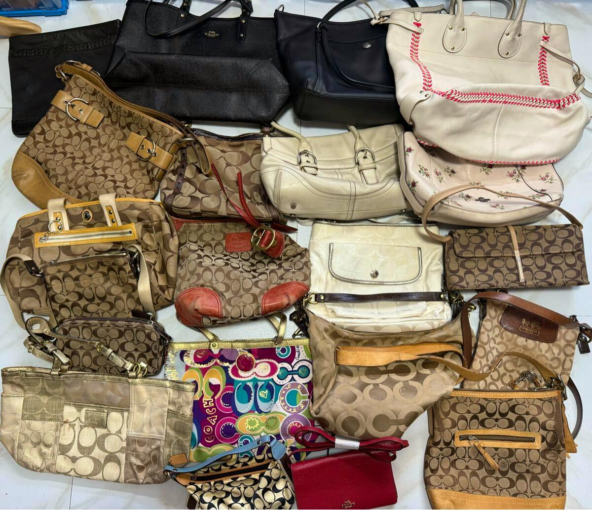 A collection of Coach bags and purses arranged together showing signature canvas and leather styles.