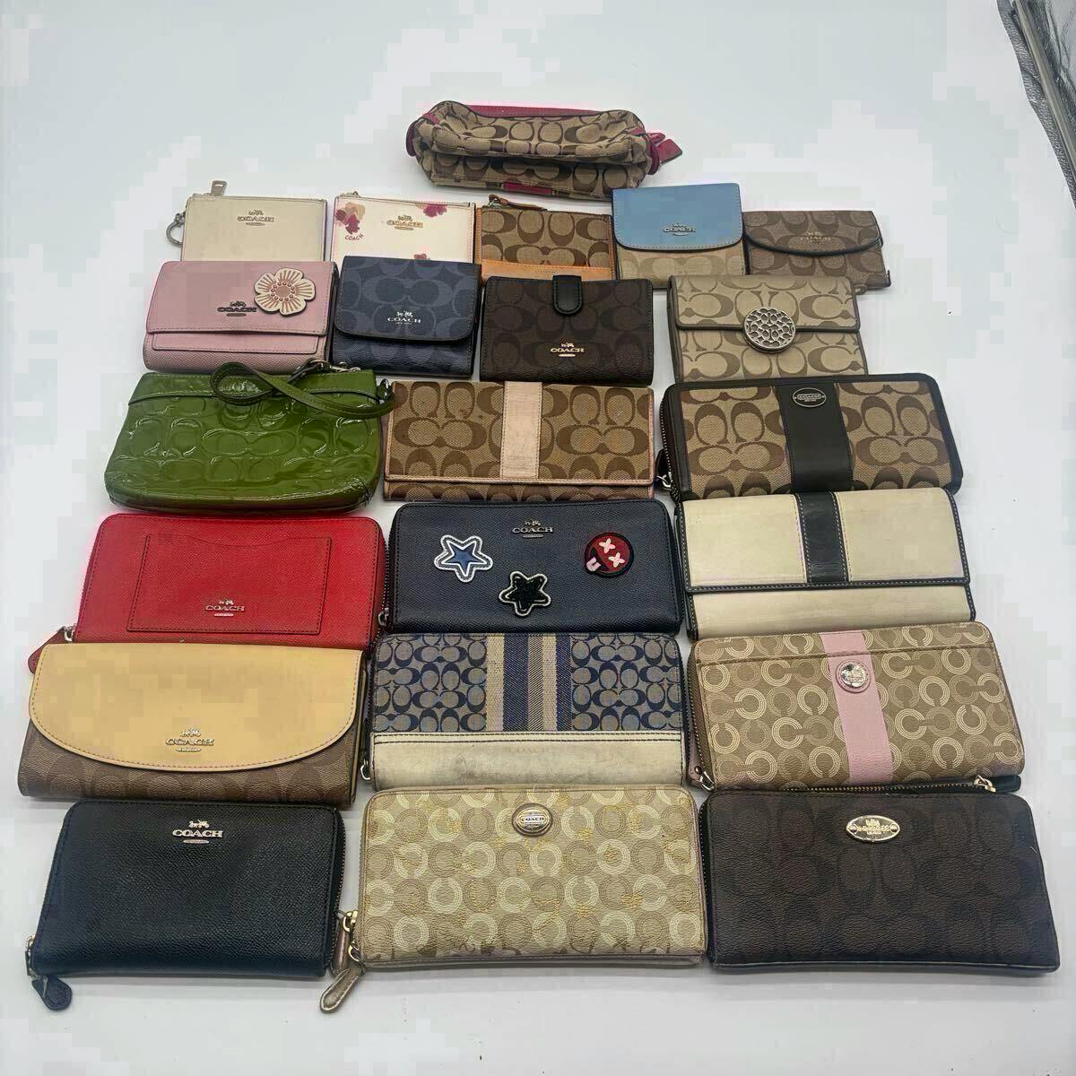 Flat lay of an assorted set of Coach wallets, long wallets, key cases, and small pouches arranged on a white background.