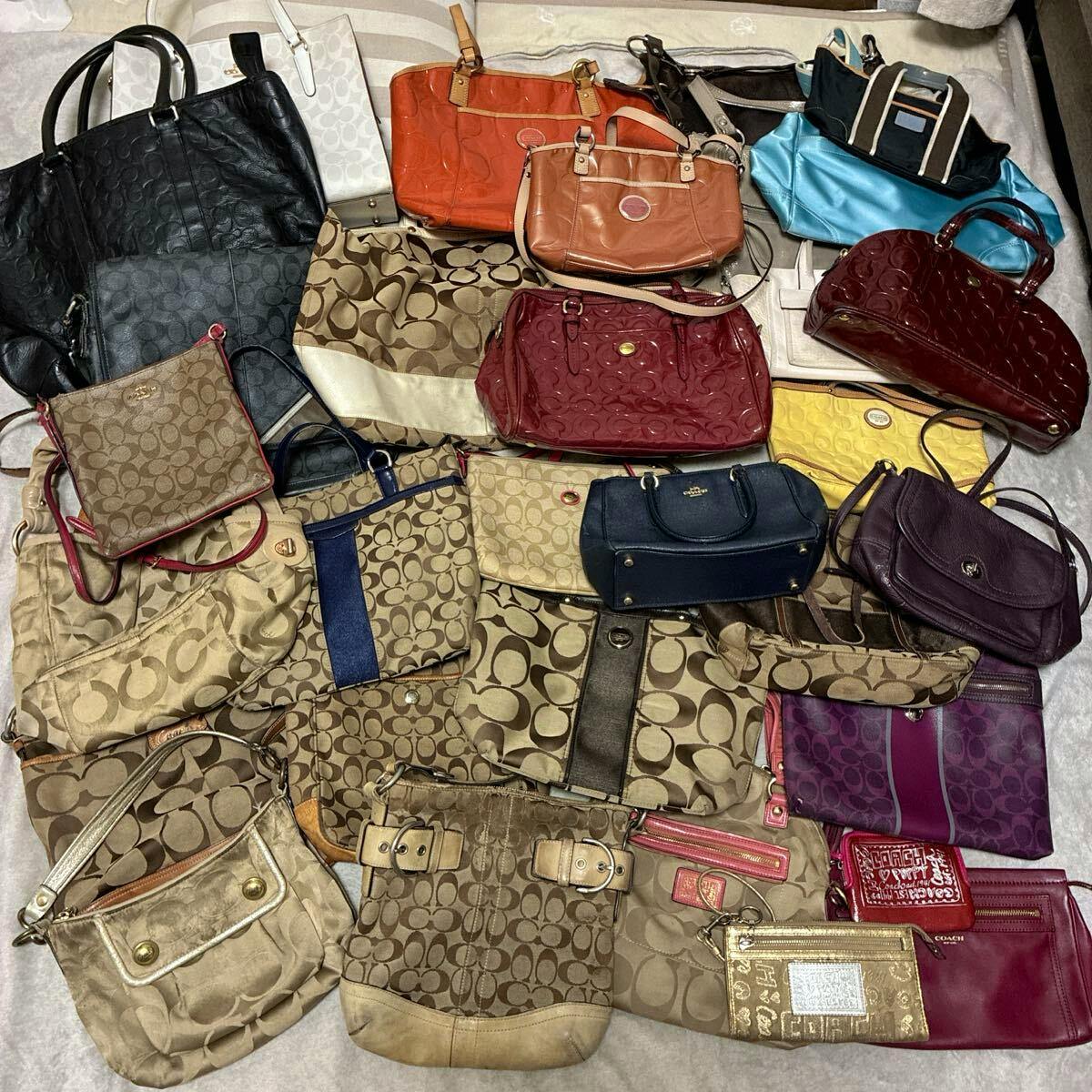 A bulk set of Coach bags and purses of various styles and colors laid flat on a surface.